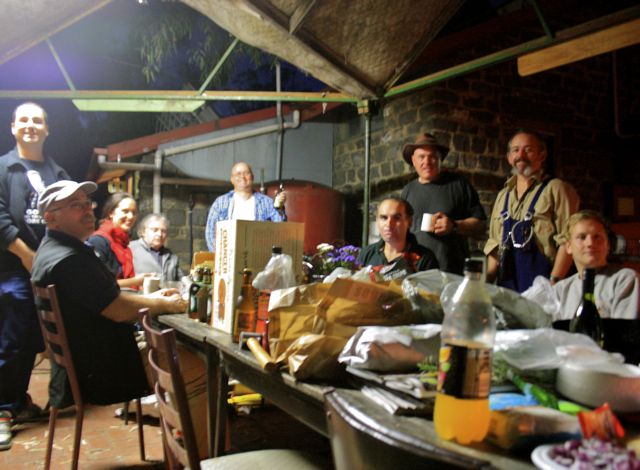 Bike Shed volunteers sit and stand around a table laden with food